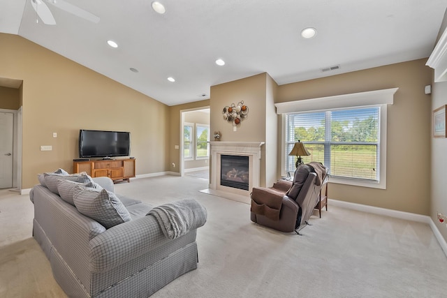 living room with ceiling fan, lofted ceiling, and light carpet