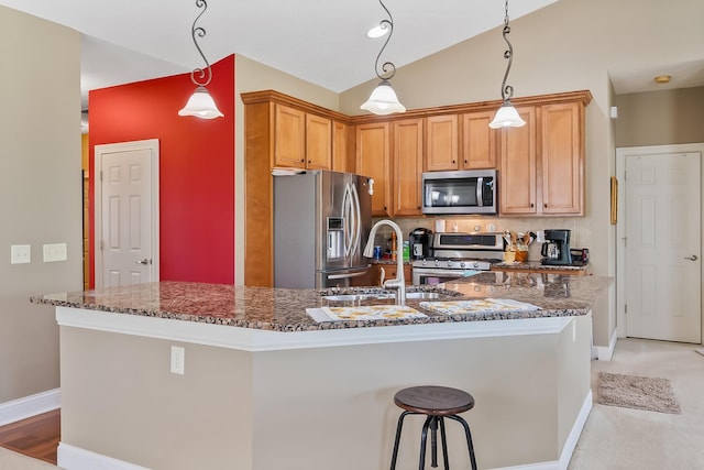 kitchen with appliances with stainless steel finishes, dark stone counters, sink, decorative light fixtures, and lofted ceiling