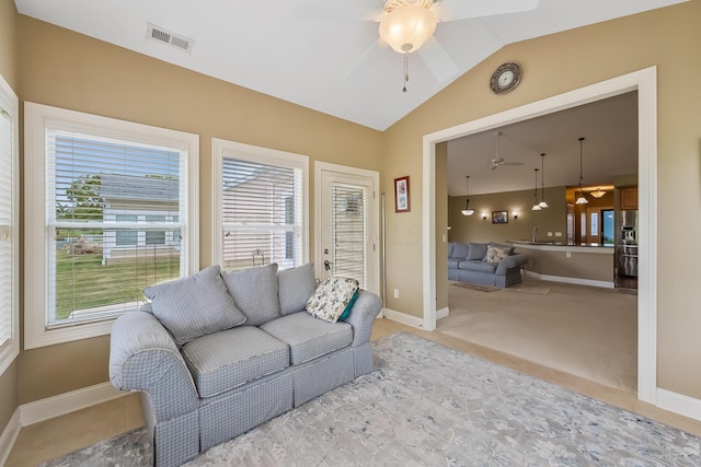 living room with ceiling fan, light colored carpet, a wealth of natural light, and vaulted ceiling