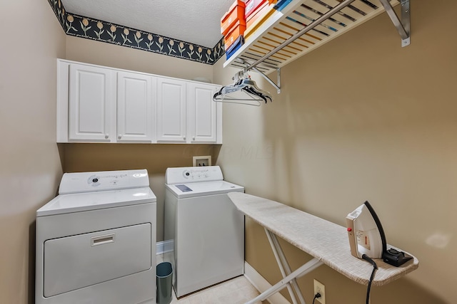 laundry room featuring cabinets, a textured ceiling, and independent washer and dryer