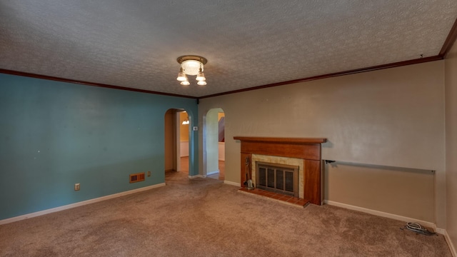 unfurnished living room with carpet flooring, crown molding, a textured ceiling, and a tiled fireplace