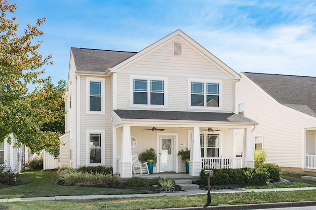 view of front of home with ceiling fan, covered porch, and a front yard