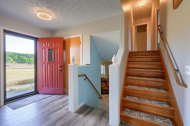 foyer entrance featuring wood-type flooring and a textured ceiling