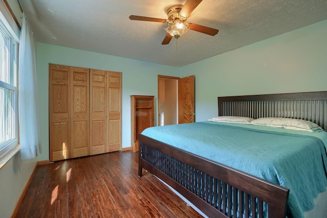 bedroom featuring a textured ceiling, ceiling fan, dark wood-type flooring, and a closet