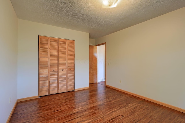 unfurnished bedroom with a closet, wood-type flooring, and a textured ceiling