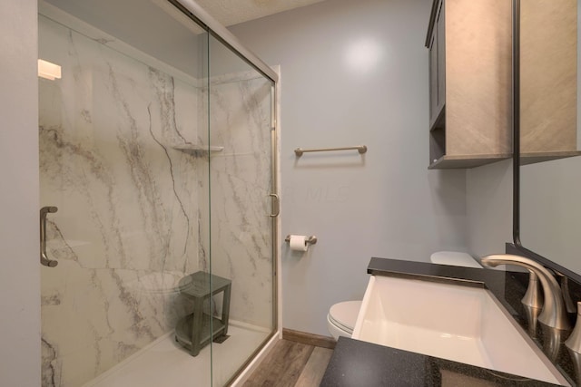 bathroom featuring toilet, vanity, an enclosed shower, and hardwood / wood-style flooring