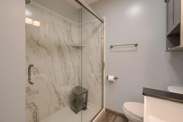 bathroom with hardwood / wood-style floors, toilet, and walk in shower