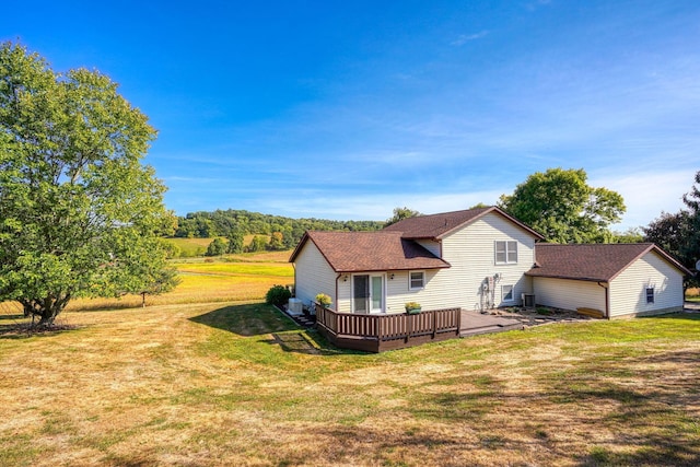 rear view of house featuring a yard and a deck