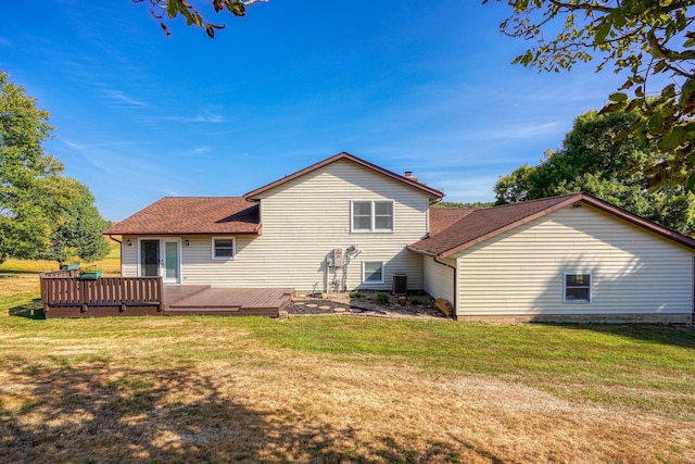 rear view of house featuring a lawn and a wooden deck