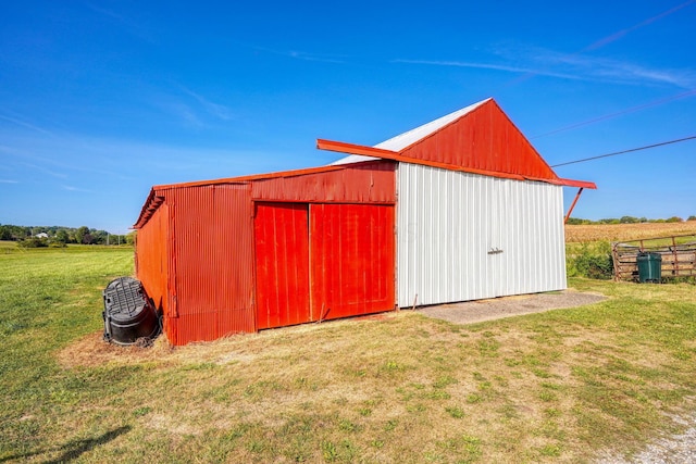 view of outdoor structure with a rural view and a lawn