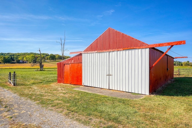 view of outbuilding with a lawn and a rural view