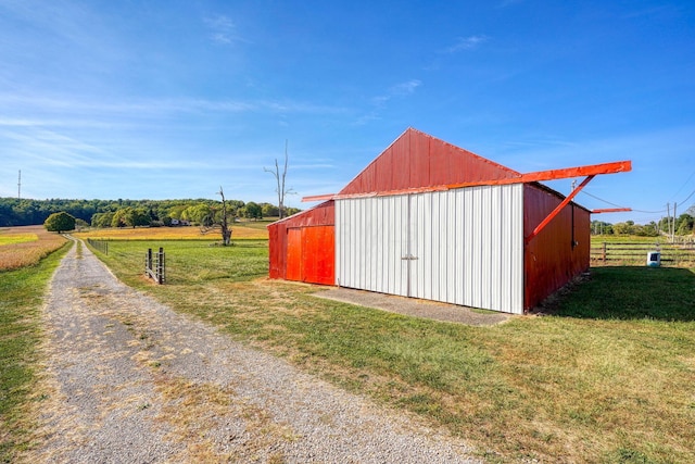 view of outbuilding with a rural view and a lawn