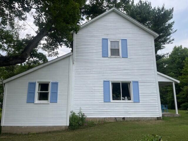 back of house with a lawn