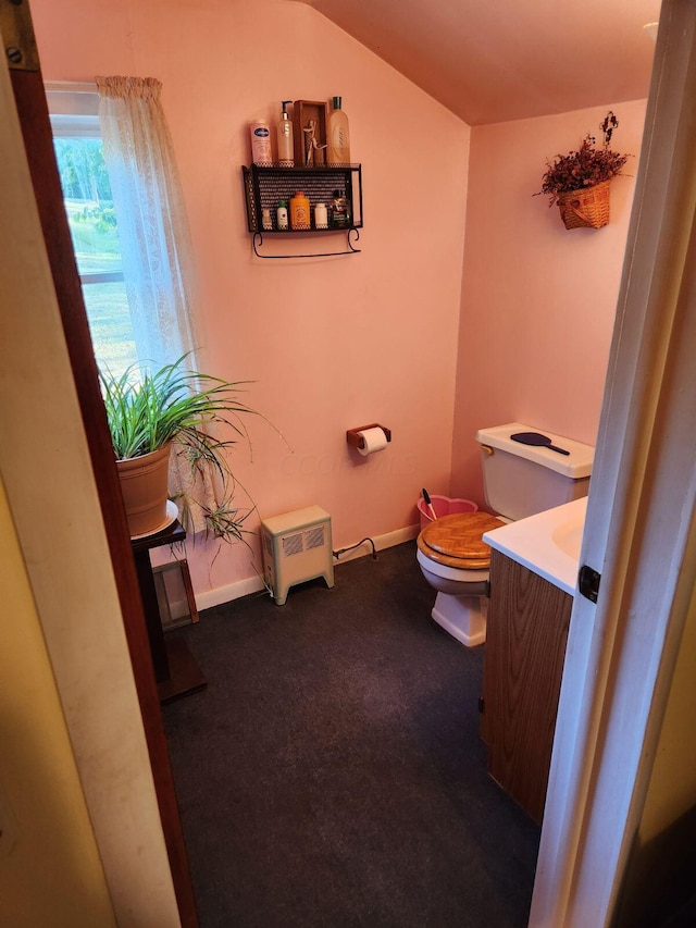 bathroom with vanity, toilet, and vaulted ceiling