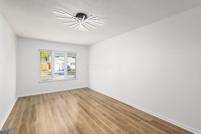 empty room featuring light hardwood / wood-style flooring and a textured ceiling