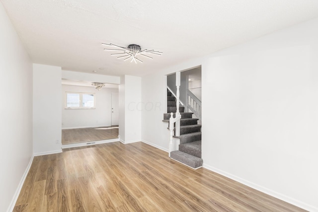 unfurnished room featuring wood-type flooring and a textured ceiling