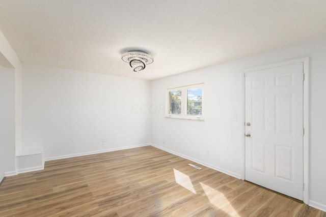 empty room with hardwood / wood-style flooring and a textured ceiling