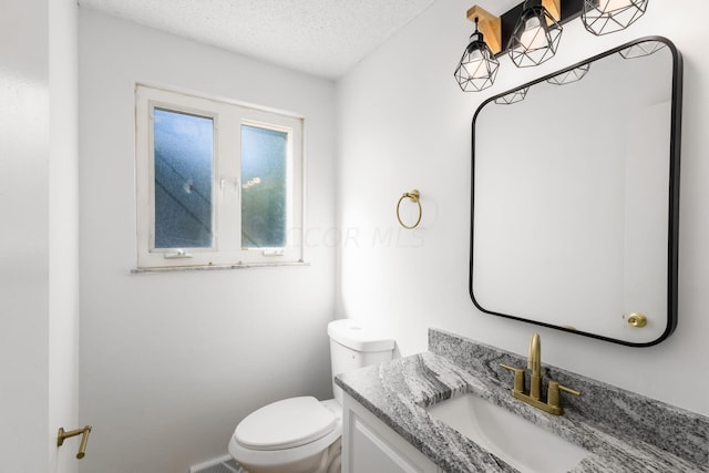 bathroom with vanity, a textured ceiling, and toilet