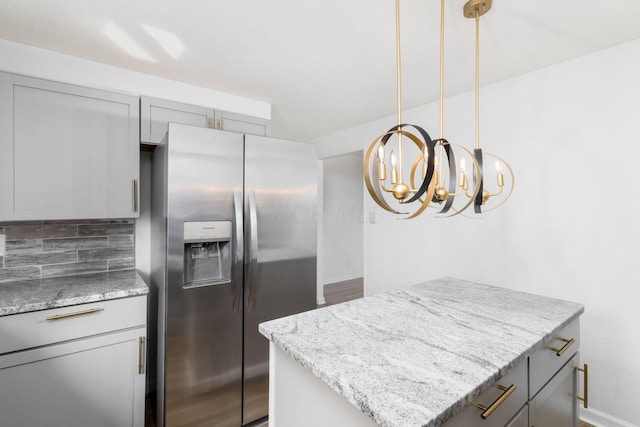 kitchen with gray cabinets, a center island, stainless steel fridge with ice dispenser, and tasteful backsplash