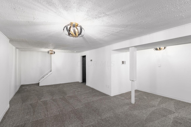 basement featuring dark carpet and a textured ceiling