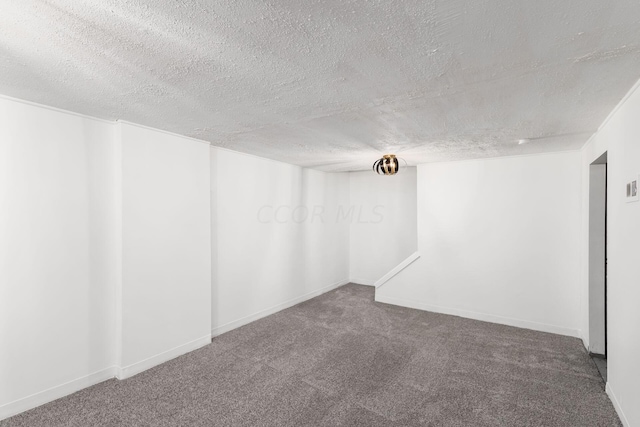 empty room with carpet flooring and a textured ceiling