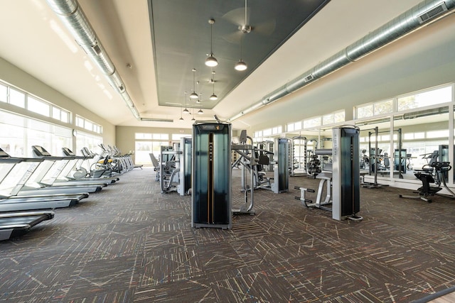 workout area with a high ceiling and dark colored carpet