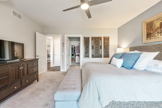 carpeted bedroom featuring a closet, a spacious closet, and ceiling fan