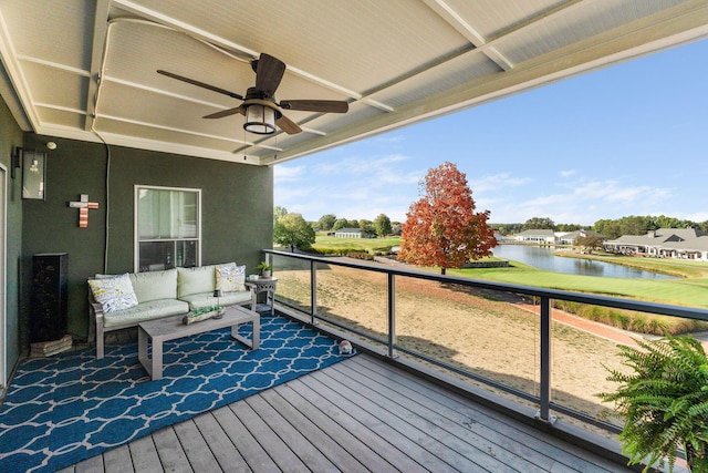 wooden terrace featuring ceiling fan, a water view, and an outdoor hangout area