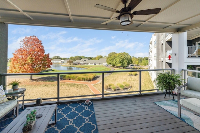 balcony featuring a water view and ceiling fan