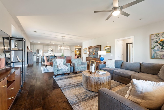 living room featuring ceiling fan and dark hardwood / wood-style floors