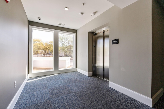 carpeted spare room with elevator