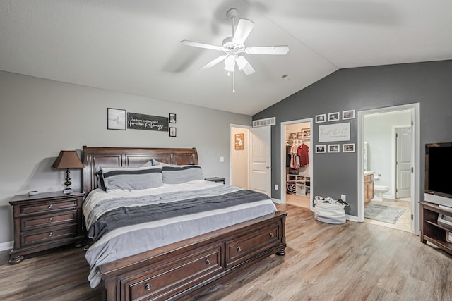 bedroom featuring ensuite bathroom, light hardwood / wood-style flooring, ceiling fan, a spacious closet, and a closet