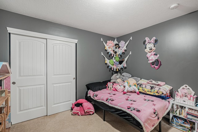 bedroom with carpet flooring, a textured ceiling, and a closet