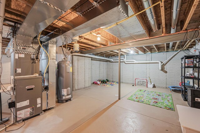 basement with heating unit, water heater, and brick wall