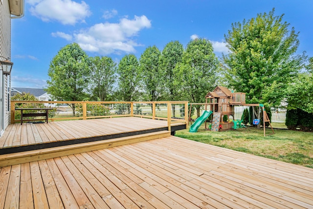 wooden deck with a playground and a lawn