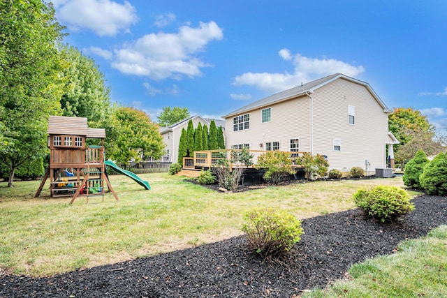 rear view of house with a lawn, cooling unit, a playground, and a wooden deck