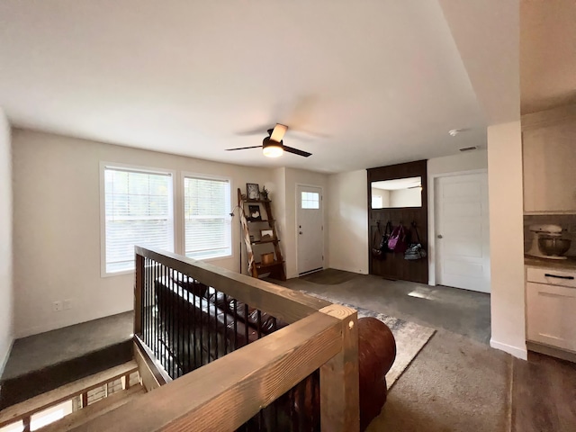 living room featuring dark colored carpet and ceiling fan