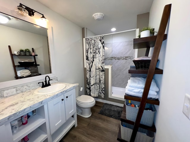 bathroom featuring hardwood / wood-style floors, vanity, toilet, and walk in shower