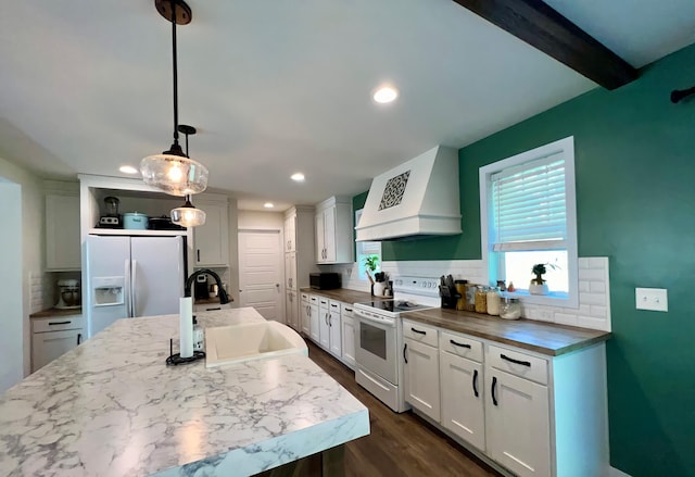 kitchen with pendant lighting, white appliances, sink, decorative backsplash, and custom range hood