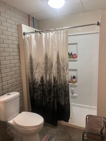 bathroom featuring curtained shower and toilet