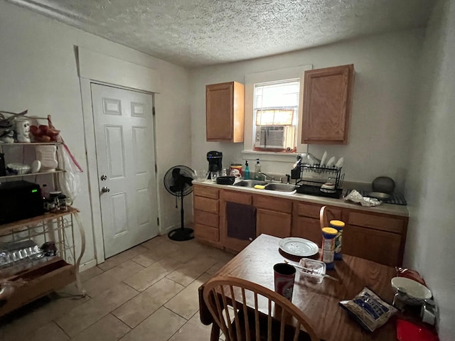 kitchen with a textured ceiling, cooling unit, and sink