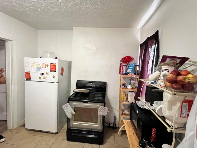 kitchen featuring black / electric stove, light tile patterned floors, a textured ceiling, and white refrigerator