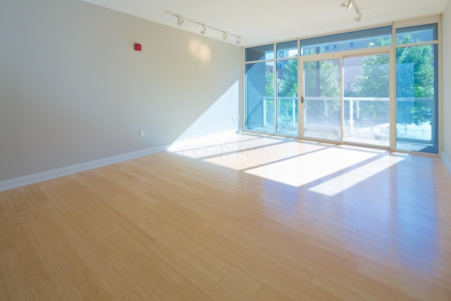 empty room featuring light wood-type flooring and rail lighting