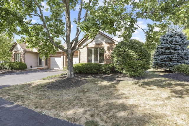 view of property hidden behind natural elements with a garage