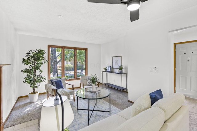 living room with ceiling fan, a textured ceiling, and light hardwood / wood-style flooring