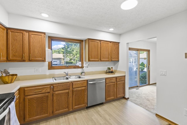 kitchen with dishwasher, light wood-type flooring, a textured ceiling, and sink