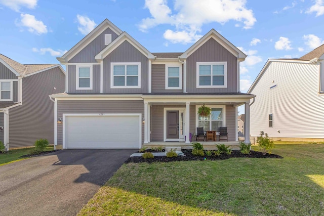 view of front of property with a front yard, a porch, and a garage