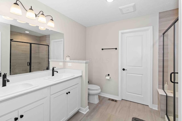 bathroom featuring vanity, toilet, and an enclosed shower