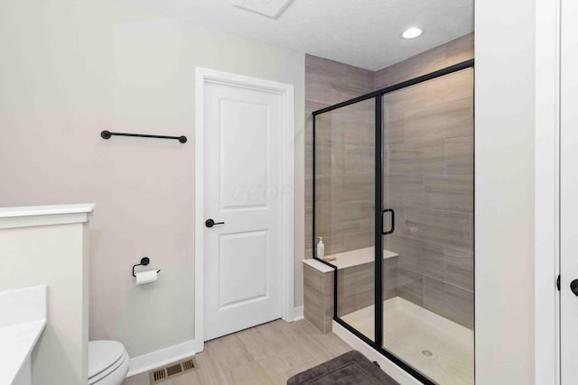 bathroom featuring hardwood / wood-style floors, toilet, and walk in shower