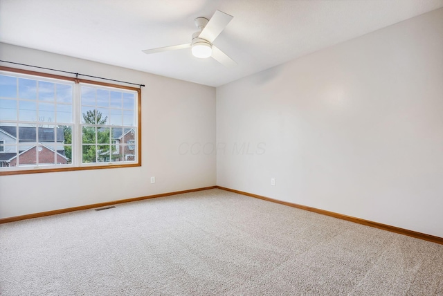 carpeted spare room featuring ceiling fan